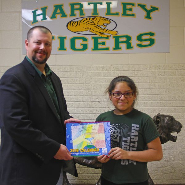 Principal Kurt Koepke presents Christy Hernandez Zamarrippa with the 2018 NPGCD Water Conservation Calendar with her artwork showcased on the cover.